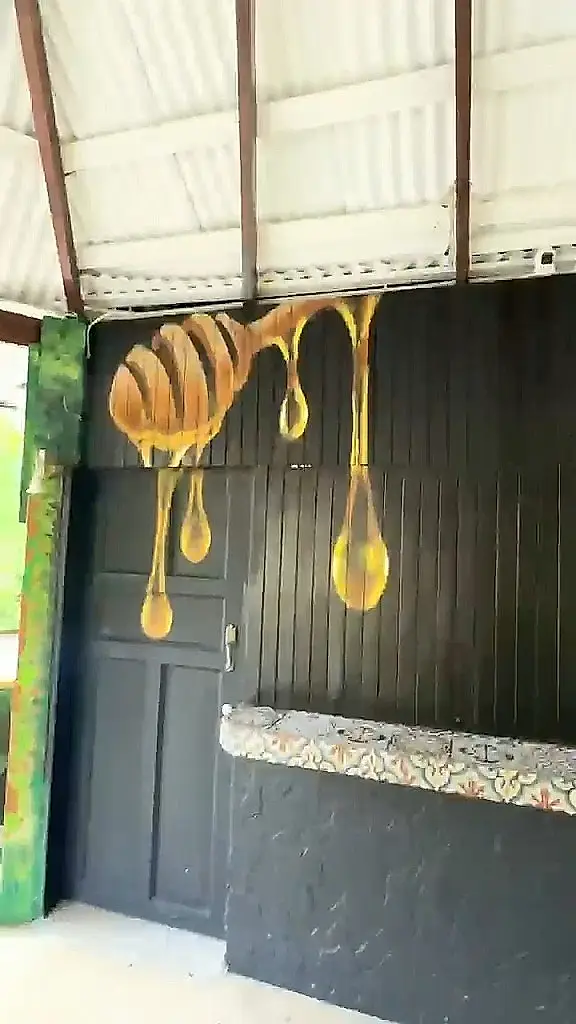 Barra negra con una cuchara de miel pintada